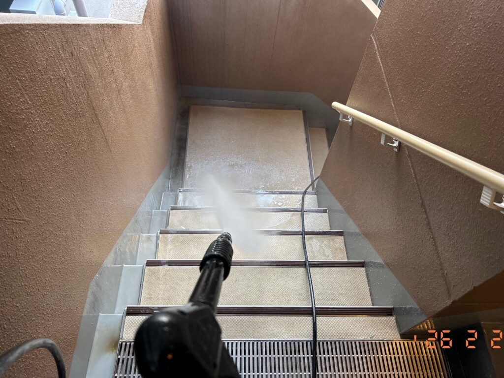 外階段を高圧洗浄で清掃中