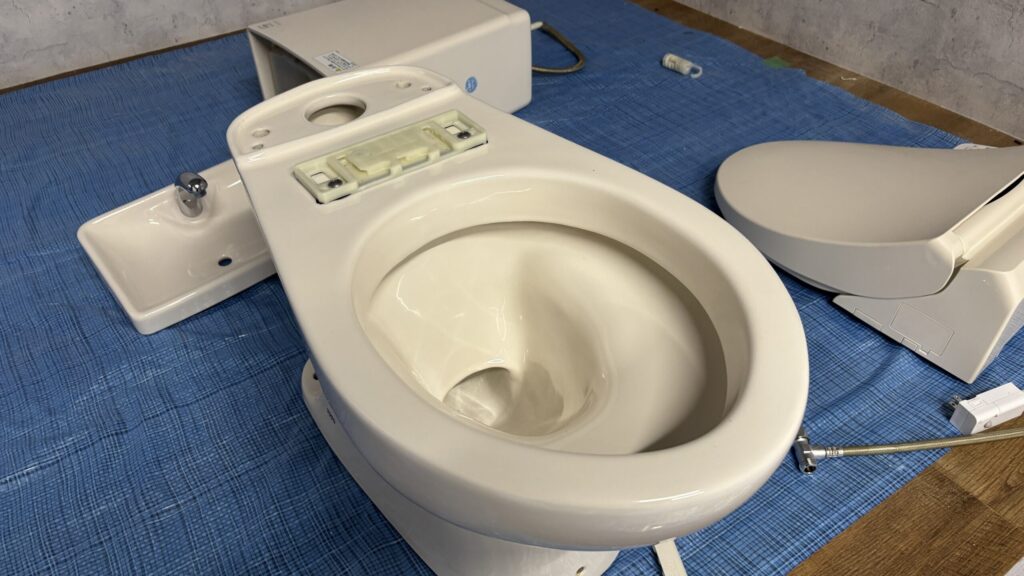 分解して丁寧に清掃中のトイレ便器と部品