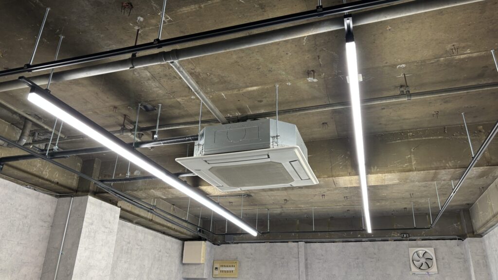 改修工事中のテナント内観と清掃済みの換気扇・天井設備