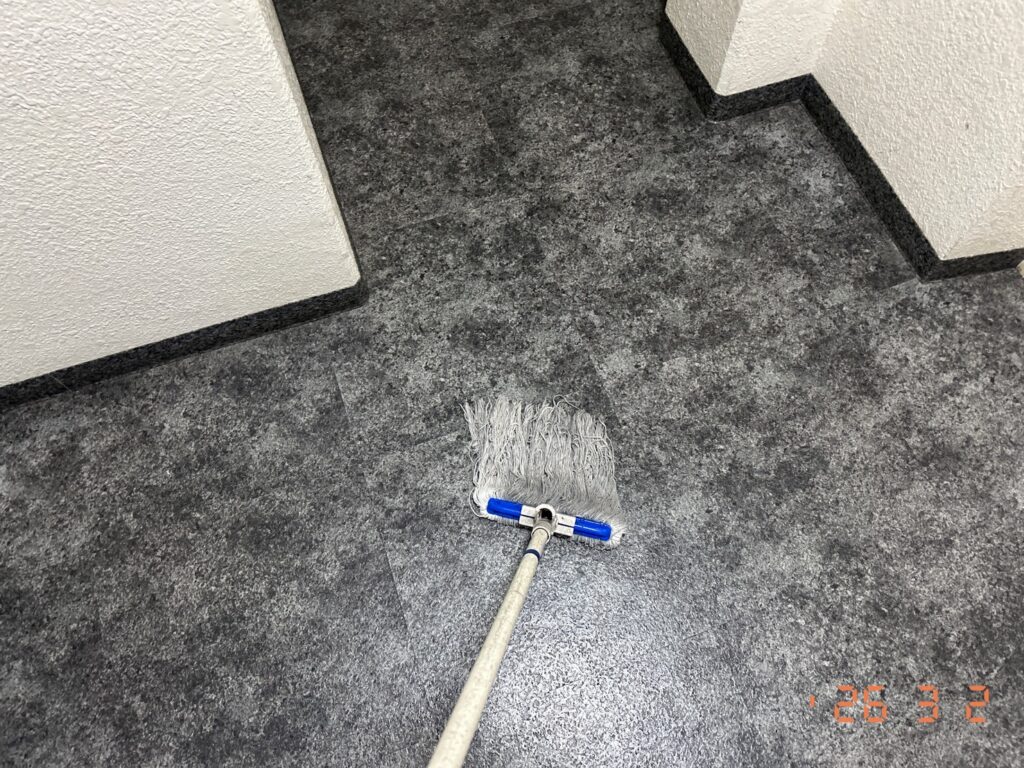 床面をモップで拭きあげています