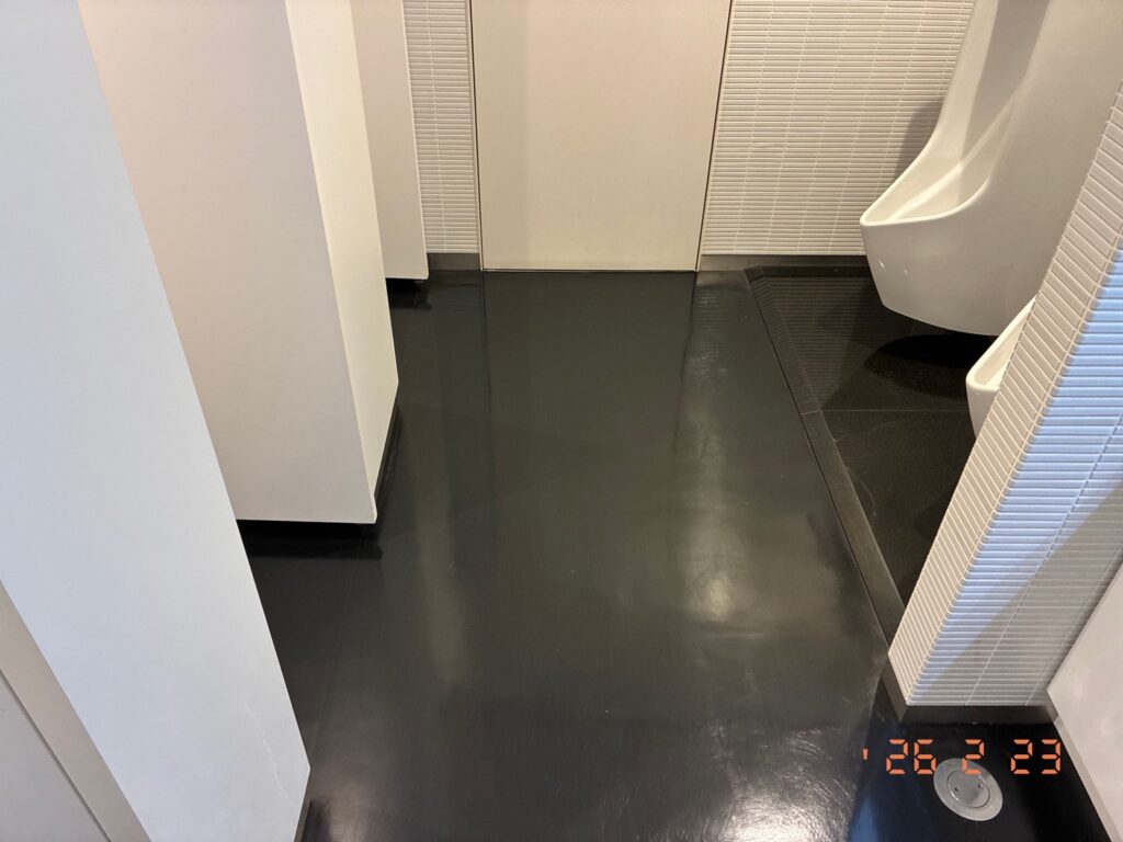 洗浄作業が完了し、美しい光沢と清潔感を取り戻したトイレの床面