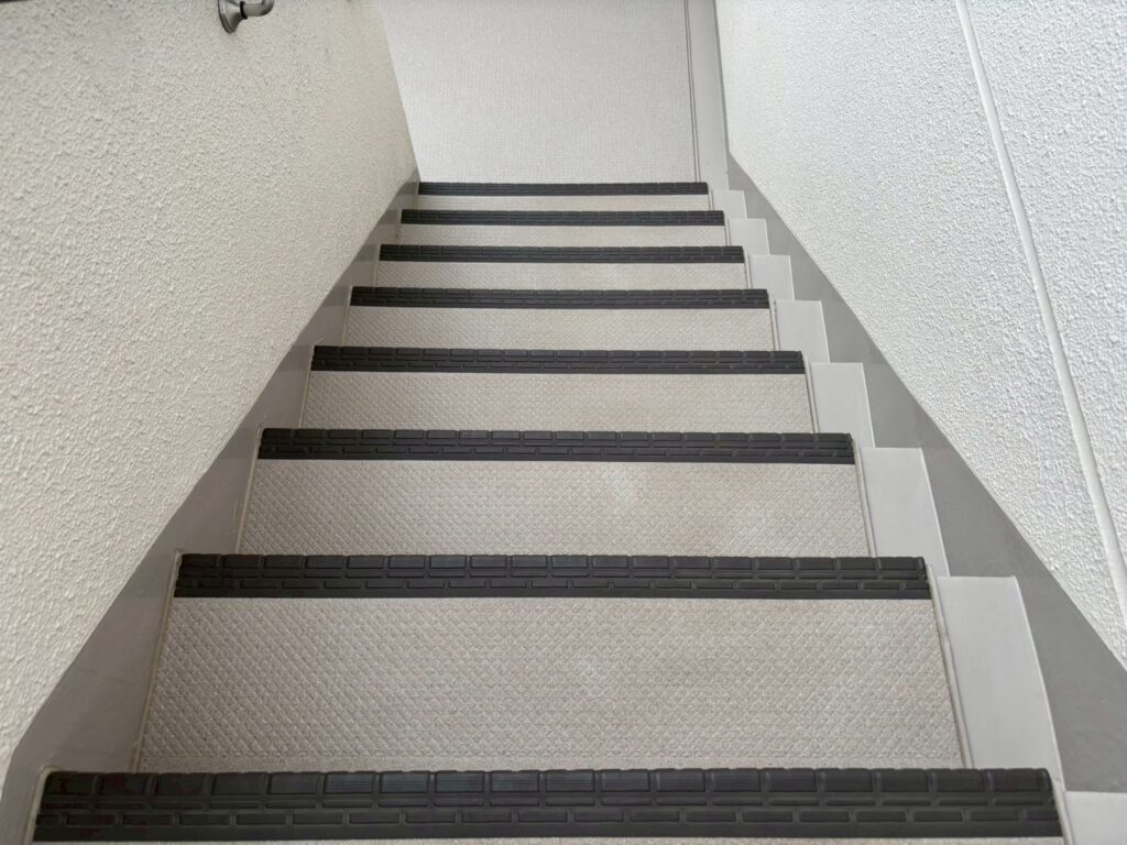 階段全体を見下ろした清掃風景と前後比較。貼り替えたばかりのような美しい階段に生まれ変わった