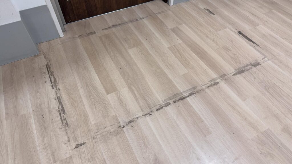 介護施設食堂の床面のビフォーアフター。左の施工前はマットをテープでとめていたためテープ跡がついています。そのまわりには油汚れで黒ずんでいる