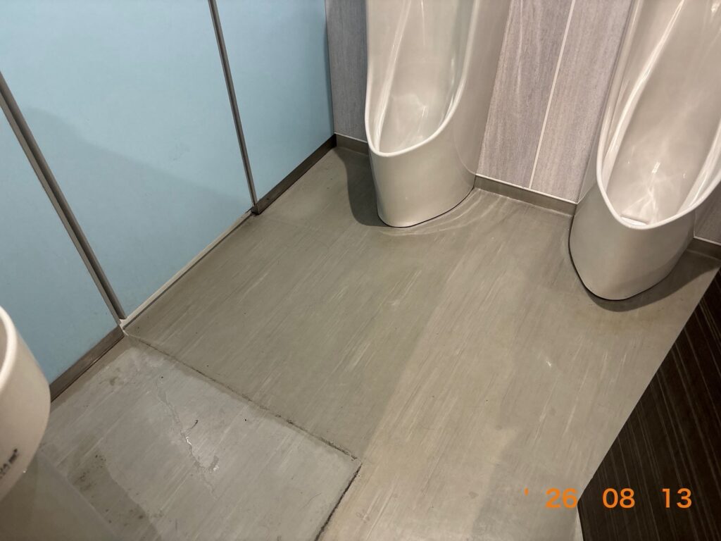 作業前のトイレ床。床材の表面がくすみ、汚れがうっすら広がっている状態。